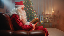 Santa Relaxing in his house reading a book