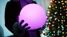 Magical sphere changing colors in the hands of Santa