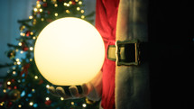 santa claus holding a magical ball
