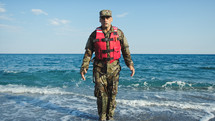Military usa man training jumping jack in the shore near the ocean