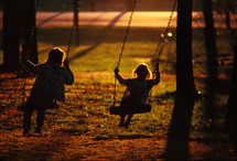Kids swinging at sunset 