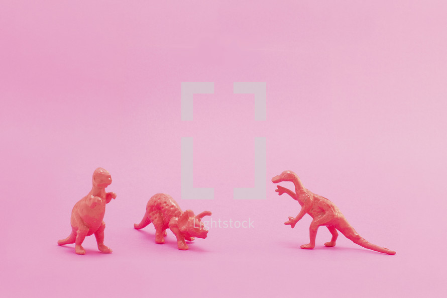 dinosaur figurine on pink background 
