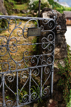Wrought iron gate on a stone wall.