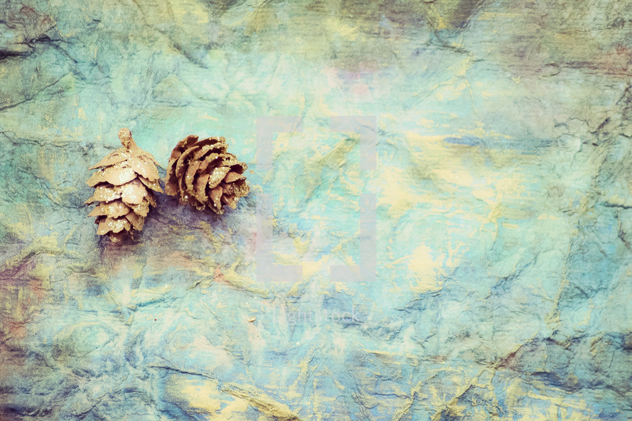 pine cone on blue green crinkled background 