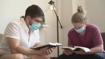 Men wearing face masks reading and discussing scripture