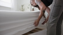 woman making a bed 
