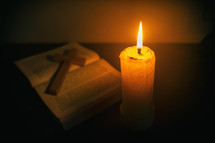 Candle on wooden table with the Bible and cross in the night. worship prayer and bible study concept.