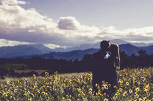 couple kissing in a field of wildflowers 