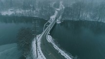 falling snow over a river and bridge 