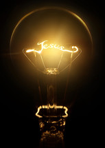 word Jesus in the filament of a glowing lightbulb 