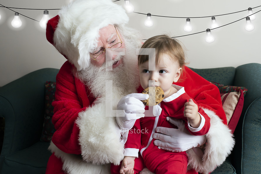 a toddler eating a cookie on Santa's lap 