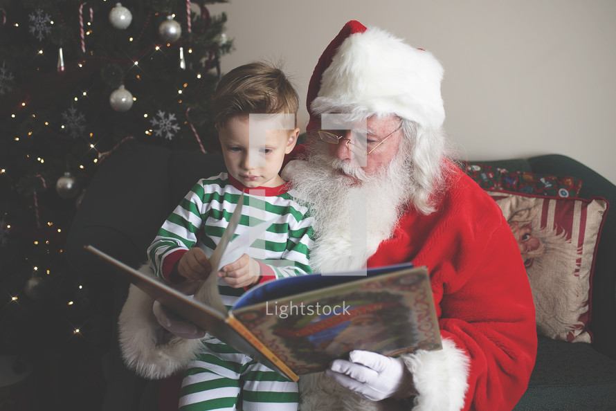 Santa and a boy reading a book together 