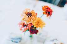 Flowers in a vase on a white tablecloth.