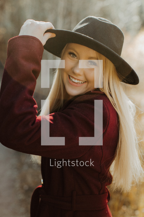 smiling woman in a coat and hat 