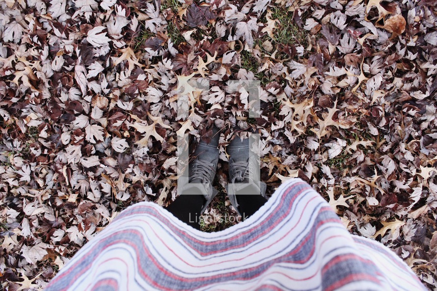 girl standing in fall leaves 