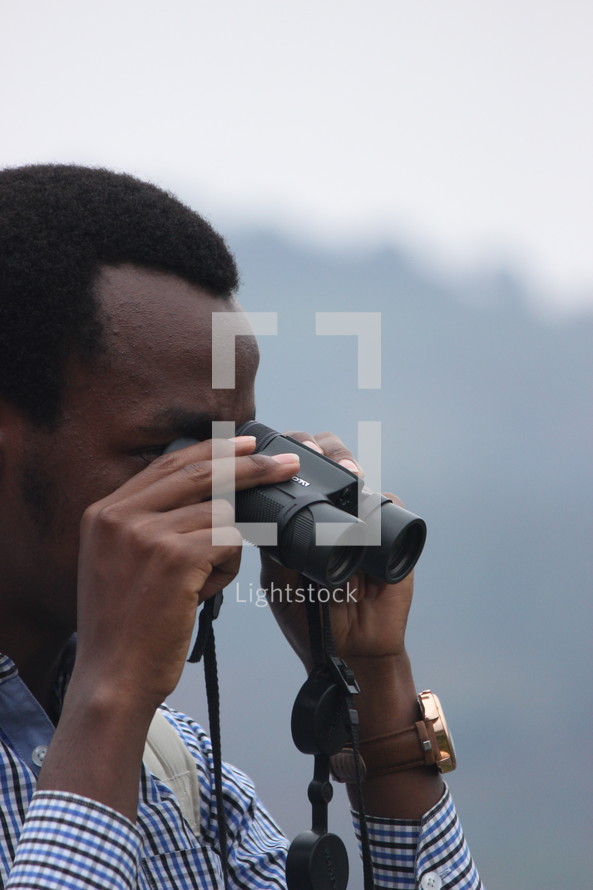 a man looking through binoculars 