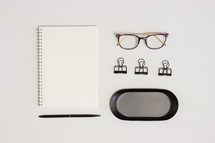 glasses and notebook on a desk 