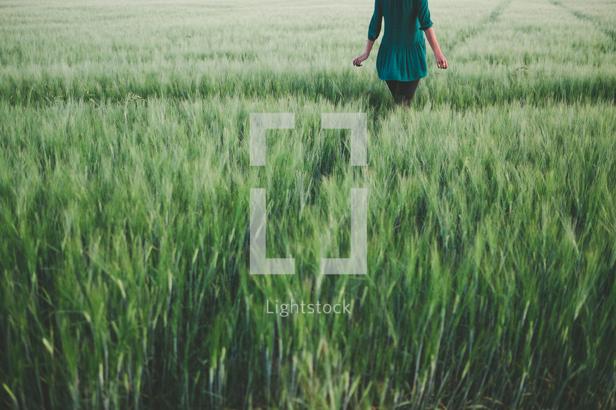 A woman standing in a field of green grass.