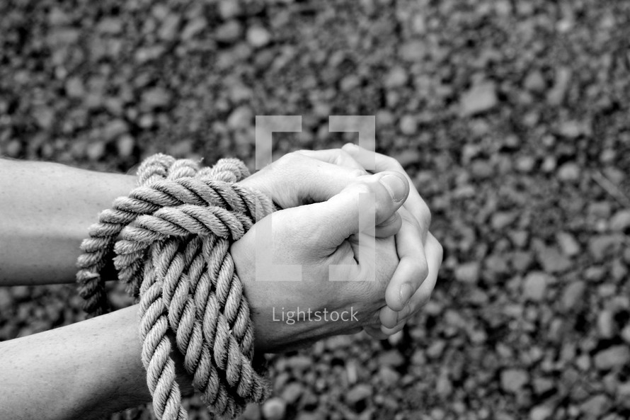 praying hands bound in rope