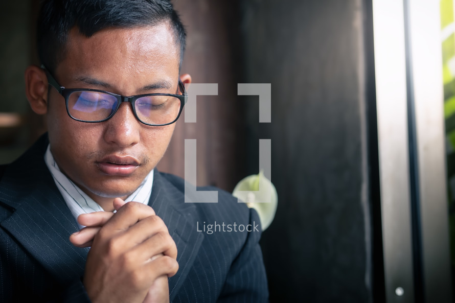 Close up young christian man praying. copyspace