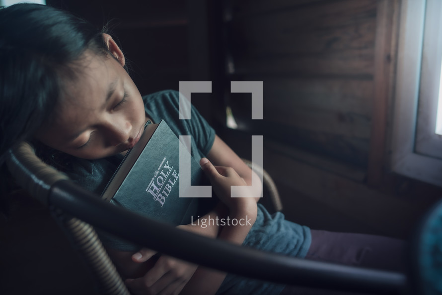 Sleeping girl holding her Bible