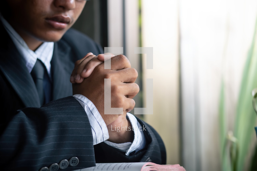 a man praying over an open Bible 