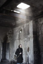 a man looking up at sunlight in an abandoned building 