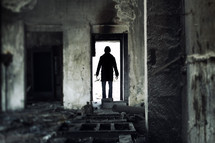 a man in a doorway of an abandoned building 
