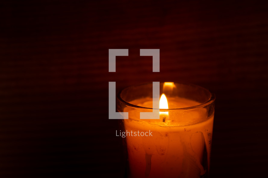 votive candle against a wood background 