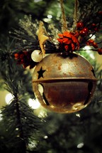 Large jingle bell ornament on Christmas tree.