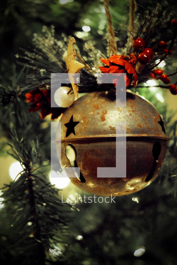 Large jingle bell ornament on Christmas tree.