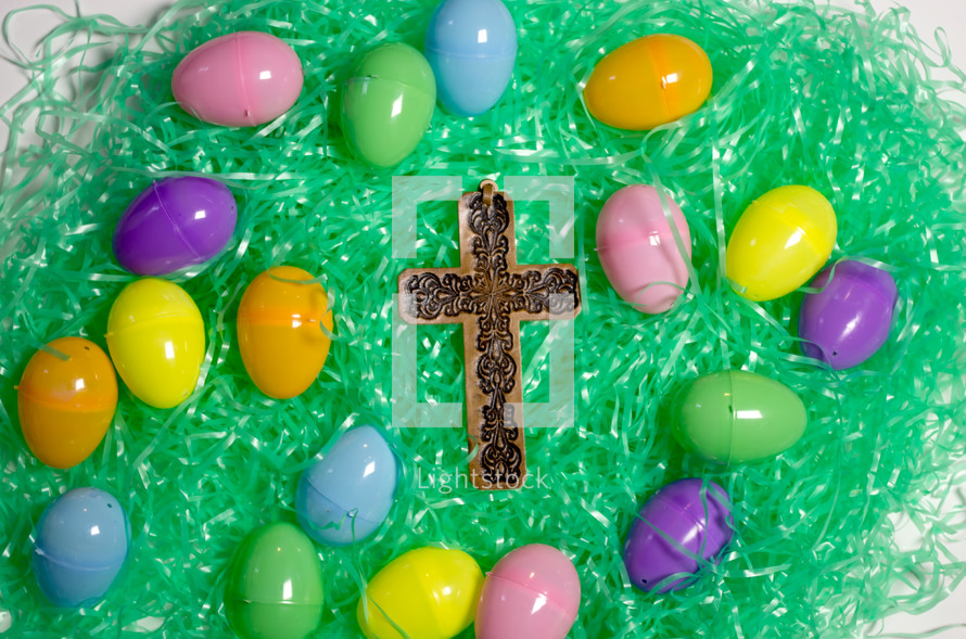 plastic Easter eggs in Easter grass with a cross 
