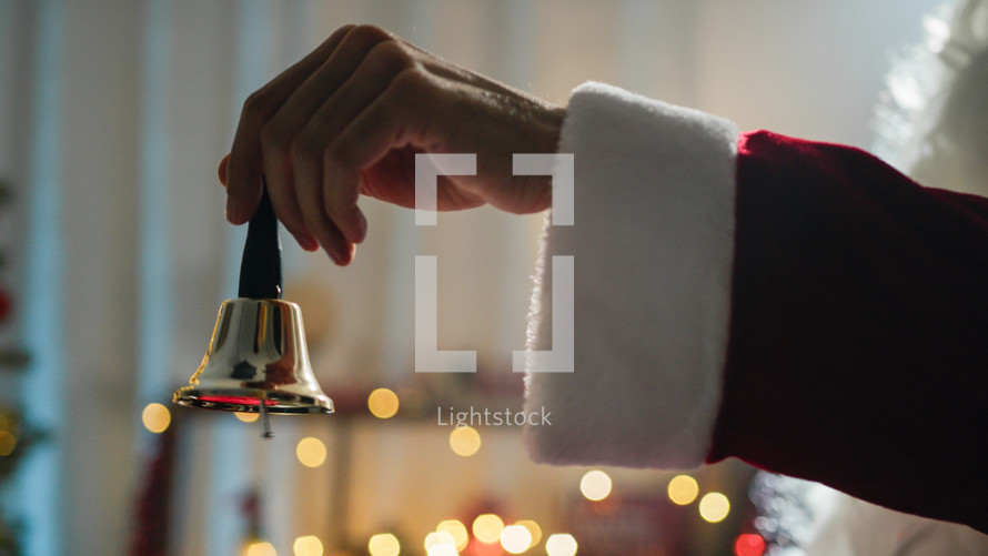 Santa ringing a small bell with his hand