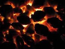 Glowing coals of a charcoal fire.