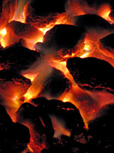 Glowing coals of a charcoal fire.