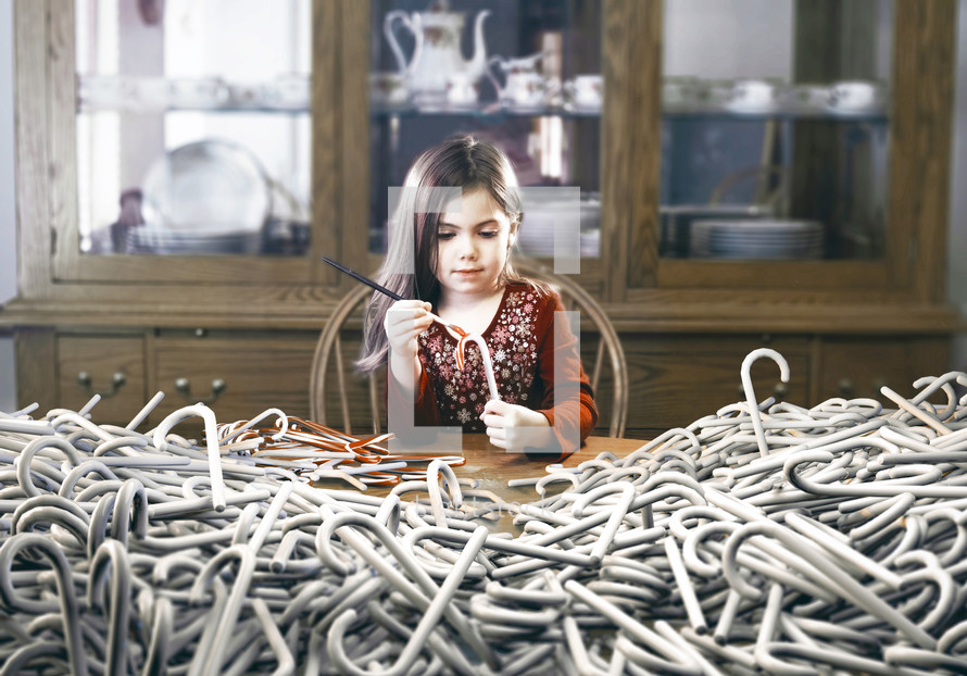 surreal image of a little girl painting hundreds of candy canes red.