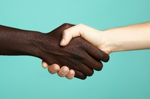 Close up of a reusable handshake between two people with contrasting skin tones