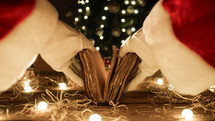 Santa Claus open a old book under tree