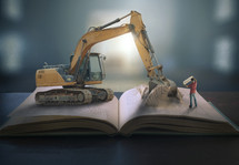 bulldozer digging into a Bible 