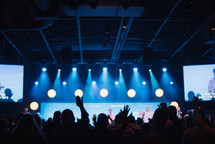 audience with raised hands at a contemporary worship service, 
