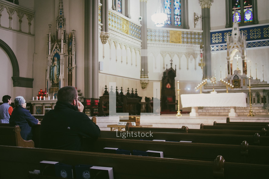 A young Catholic man praying at Eucharistic adoration in a Catholic church