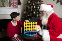 A boy and Santa playing connect four 
