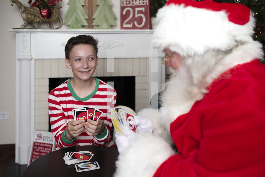 a boy and Santa playing Uno 