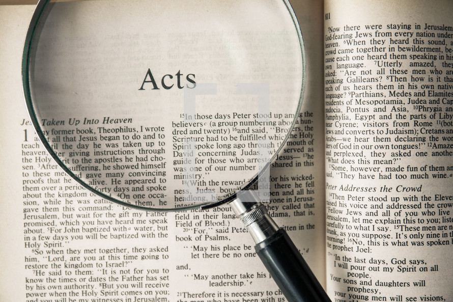 magnifying glass over Bible - Acts 