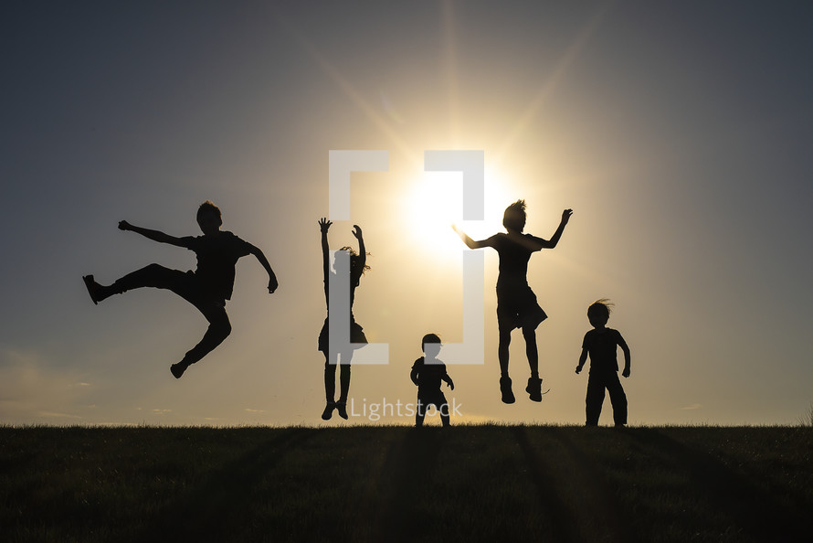 silhouettes of kids jumping 