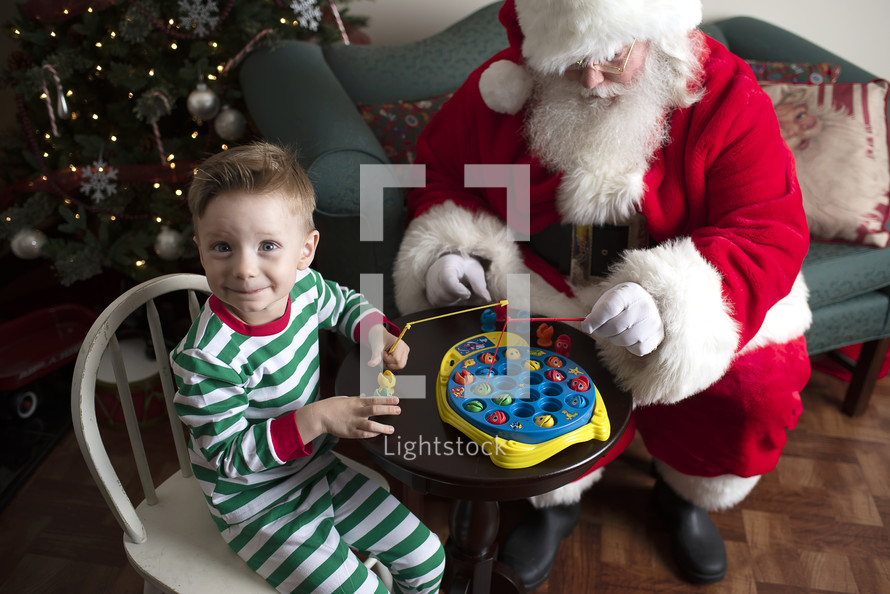 a boy playing with toys with Santa 