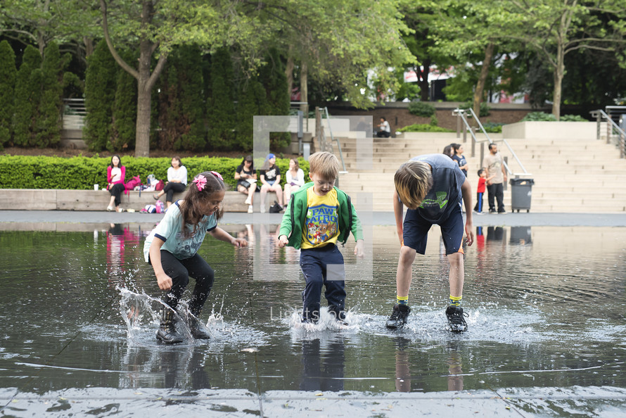 children splashing in a puddle 