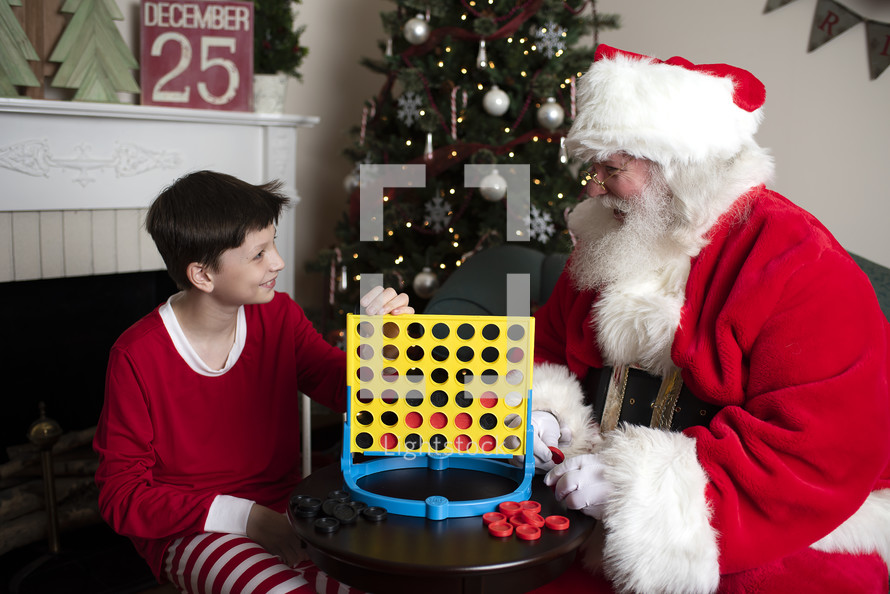 A boy and Santa playing connect four 