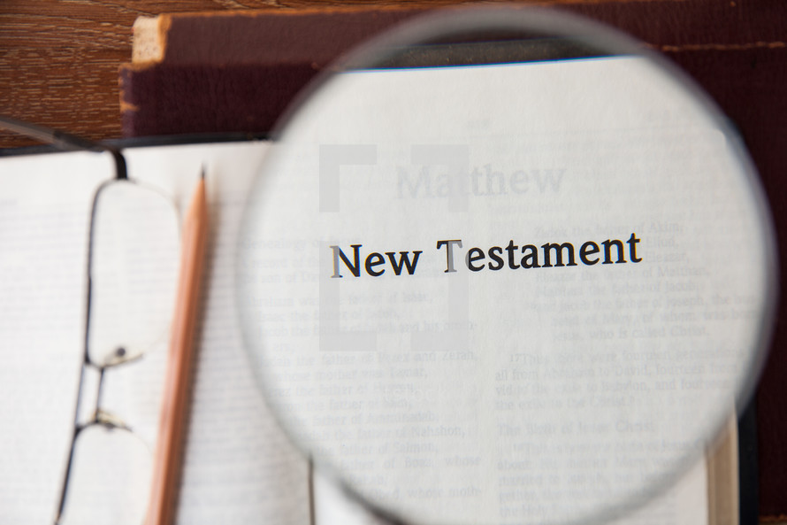magnifying glass over New Testament 