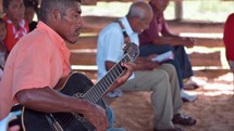 Man playing guitar in small church service in Honduras